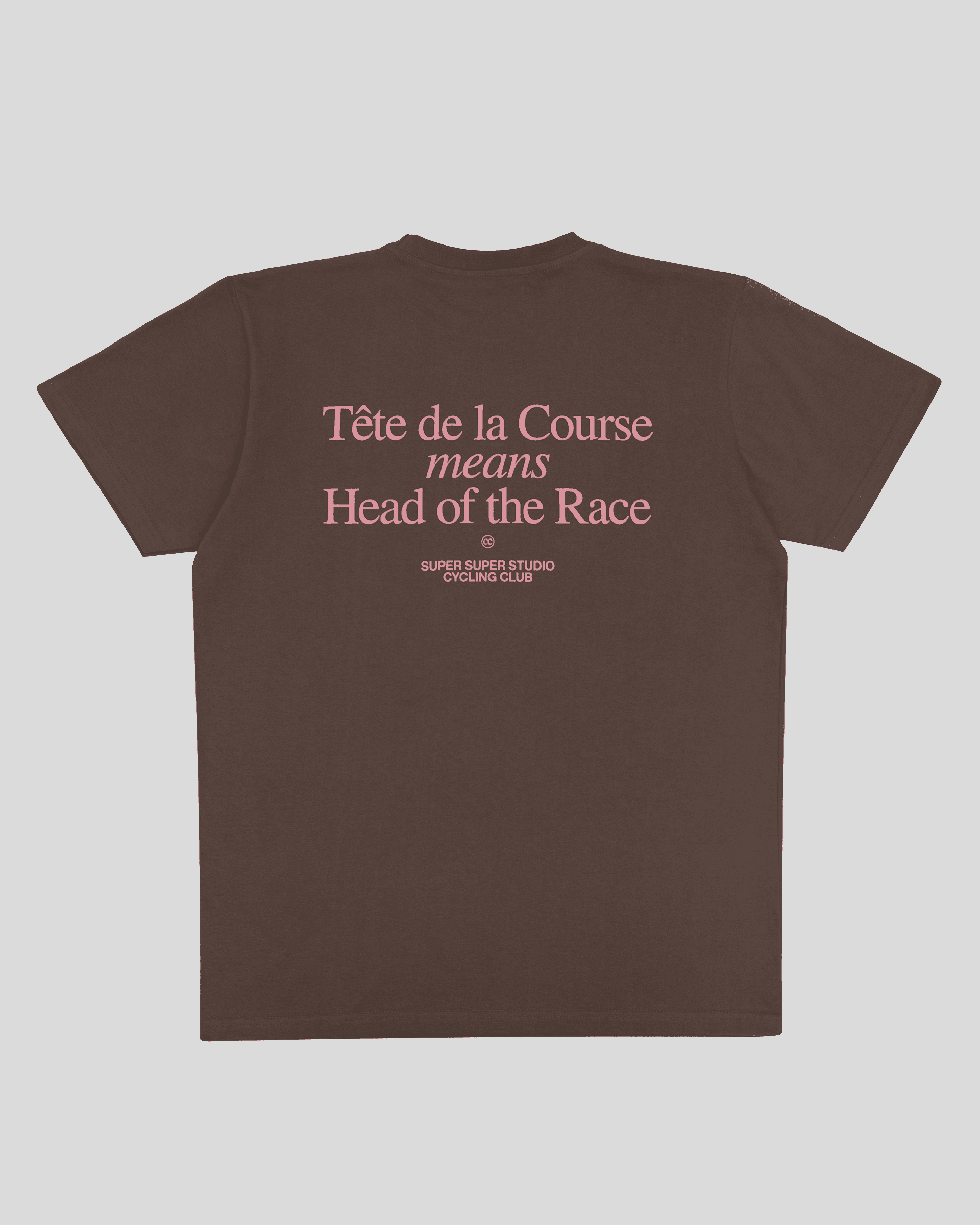 Back view of a brown T-shirt with pink text that reads 'Tête de la Course means Head of the Race' and 'Super Super Studio Cycling Club' at the bottom.